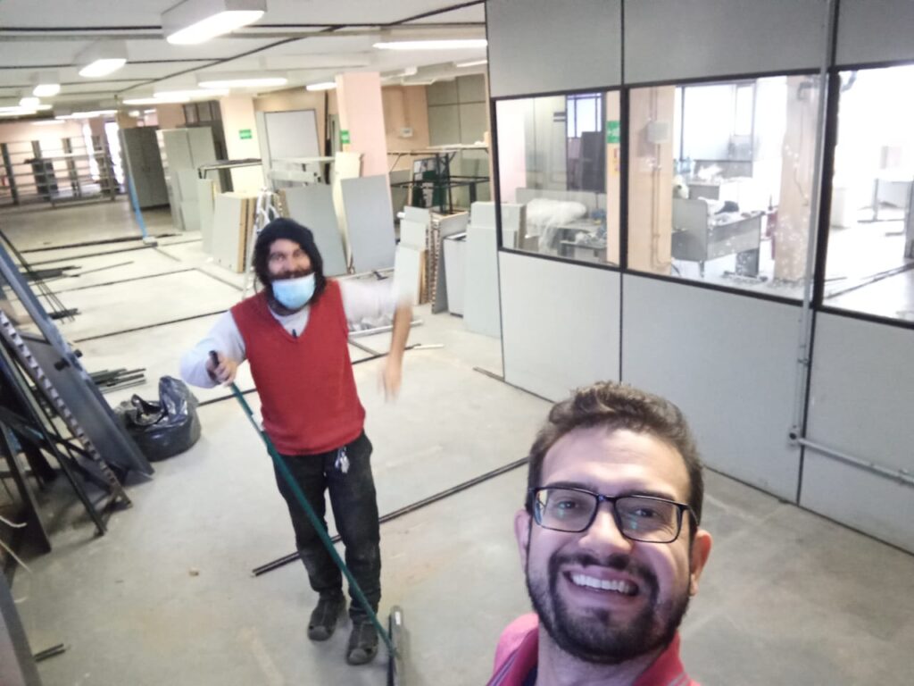Eduardo, com uma vassoura, e Gustavo, em primeiro plano, no galpão ainda em obras que viria a ser a fábrica da Ímpeto