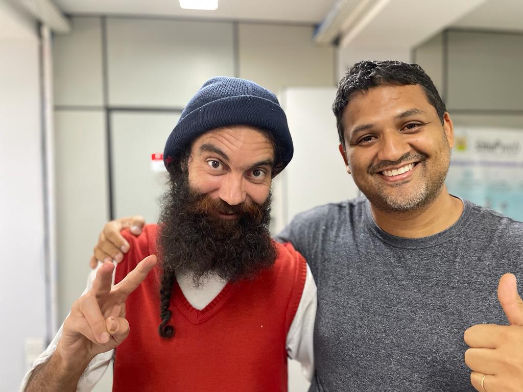 Eduardo e Daniel abraçados, sorrindo, fazendo sinal de paz e de positivo