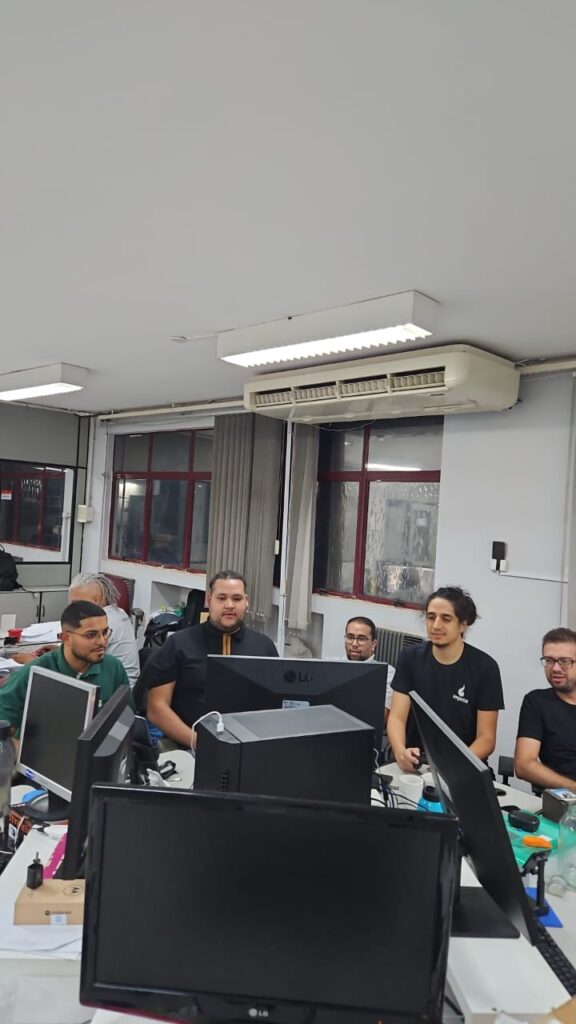 Equipe reunida à noite no escritório, em frente aos monitores, jogando juntos